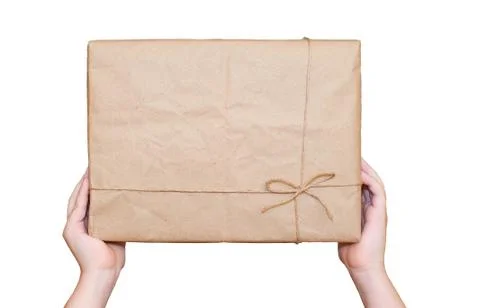Child's hands hold a rectangular cardboard box isolated on a white background Stock Photos