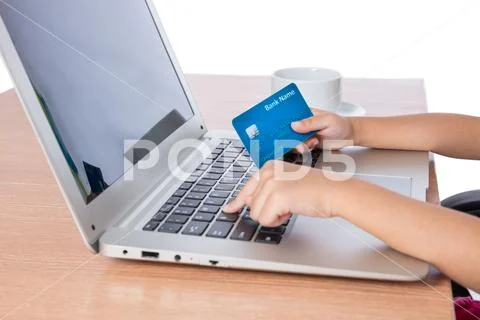 Child's hands holding credit card and typing on keyboard Stock Photos
