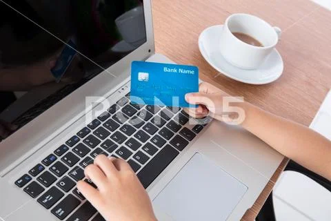 Child's hands holding credit card and typing on keyboard Stock Photos
