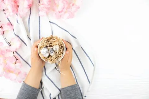 Child's hands holding Easter eggs on wooden background. Stock Photos