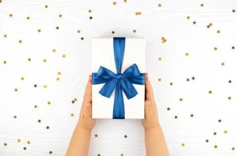 Child's hands holding gift box on white background. Stock Photos