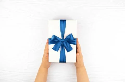 Child's hands holding gift box on white background. Stock Photos