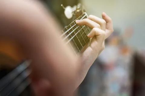 Child's hands learning to play a classic six-string steel-string acoustic g.. Stock Photos