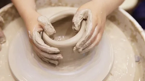 Childs hands making a clay ware on a pottery wheel. Close up Stock Footage 64230868