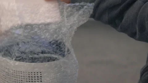 Child’s Hands Opening Small White Box Next to Wrapped Appliance Stock Footage 325948158