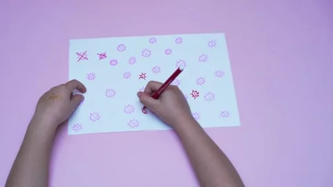 Child's hands playing game eliminating covid-19 viruses on paper Video stock 279436162