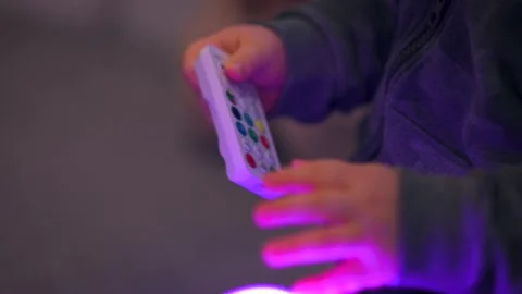 Child's Hands Playing with Remote Control: Close-Up Stock Footage 325056537