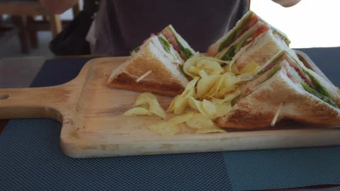 Childs hands reaching eagerly for delicious club sandwich, stacked high with Stock Footage 312741563