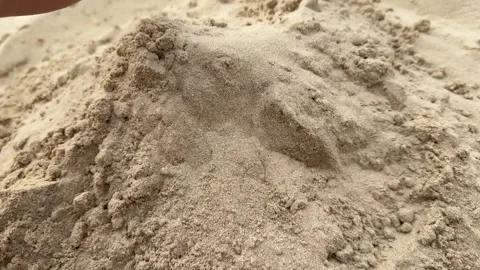 A childs hands scooping sand on the beach, building a sandcastle in a playful Video stock 305389674