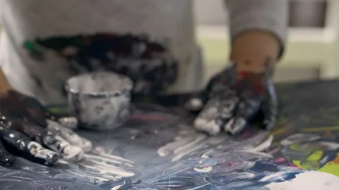 Child's hands smeared with paint draw on the paper, close-up. Video stock 167966256