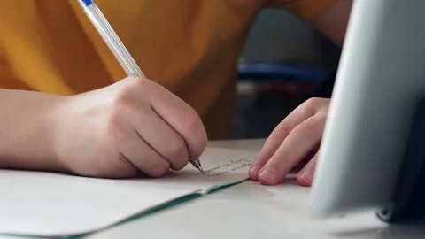 A child's hands writing with a pen in a notebook. Stock Footage