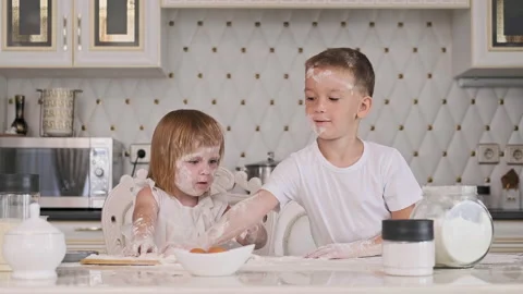 Childs having fun while cooking pie. Brother and sister playing with flour Stock Footage 138024200