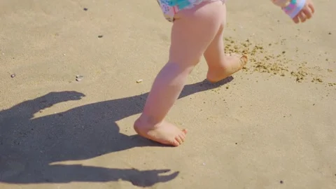 Child's playful steps and shadow on sandy beach, clear sunny day in 4k slow.. Stock Footage 286798370