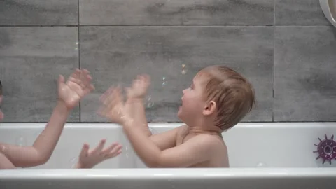 Childs playing in the bath with soap bubbles. Video stock 331254089