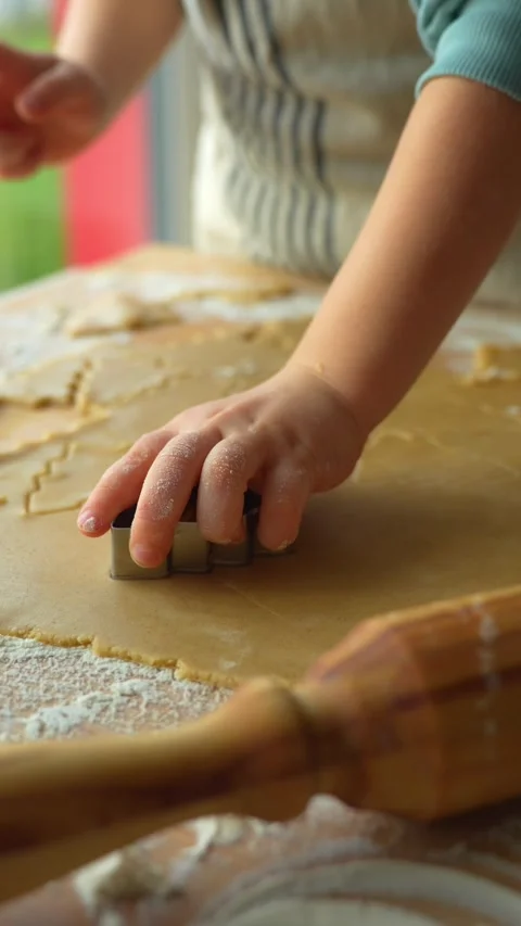 Child's small hands pressing gingerbread tree shapes out of dough. Stock Footage 294437687