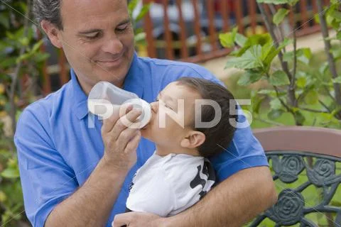 Chilean Father Feeding Bottle To Son