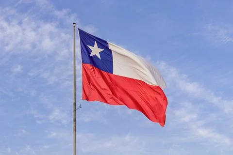 Chilean flag raised in good condition with blue sky in the background Stock Photos