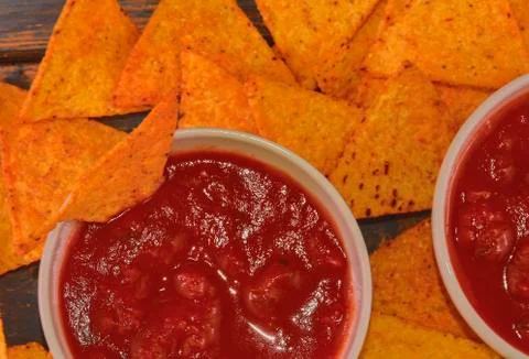 Chili corn-chips with salsa dip on wooden background Stock-Fotos