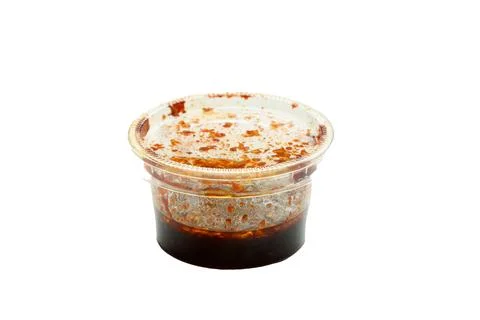 Chili paste in a plastic cup isolated on a white background. Stock Photos