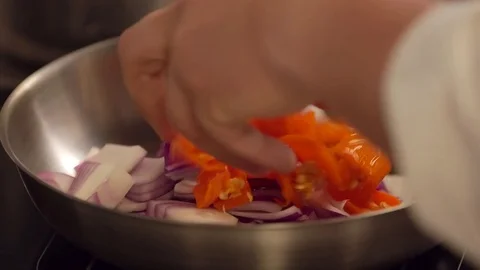 Chili pepper into skillet Stock Footage 77129462