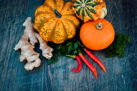 Chili peppers, ginger, pumpkins, parsley autumn vegetables on a table. Top view Stock Photos