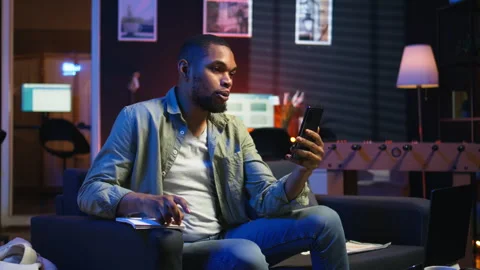 Chill self employed guy enjoying a video call on mobile phone at home Stock Footage 308261875