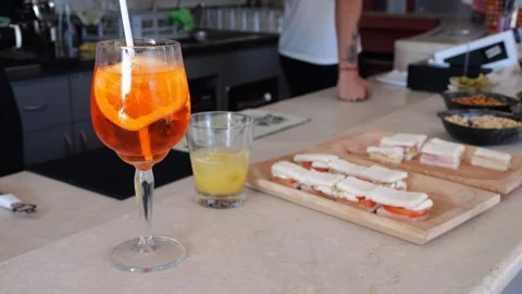 Chilled spritz cocktail with ice, accompanied by appetizer bowl, resting on.. Stock Footage 314669125