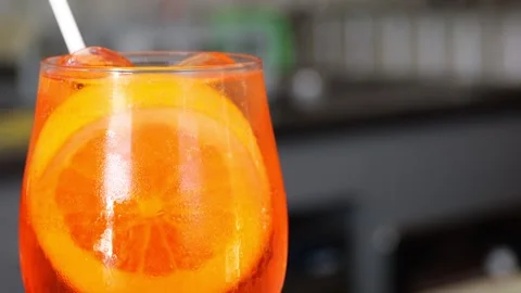 Chilled spritz cocktail with ice, accompanied by appetizer bowl, resting on.. Stock Footage 314886730