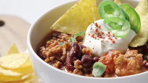 Chilli con carne served with sour cream and tortilla chips Stock-Footage 24655060