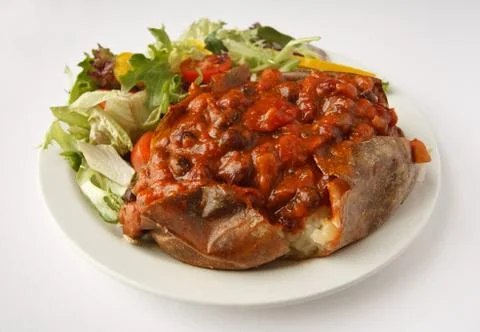 Chilli jacket potato with side salad Foto stock