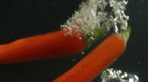 Chilli peppers fall down into water Stock Footage 127837390
