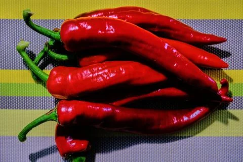 Chilli peppers on yellow-gray background Stock Photos