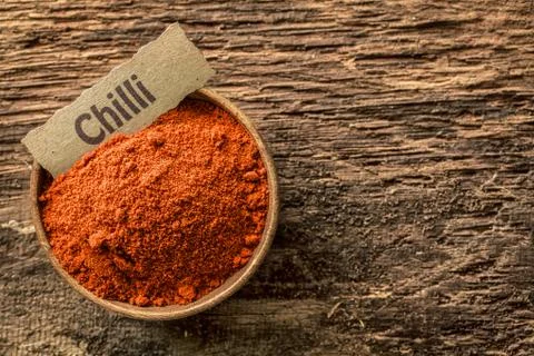 Chilli powder in a rustic wooden bowl Stock Photos