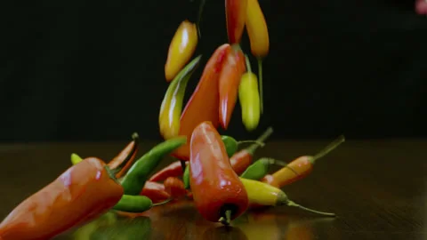 Chillies fall on tabletop slow motion Vídeo Stock 217534314