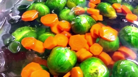 Chilling down brussel sprouts and carrots, at a restaurant kitchen Stock Footage 56138880