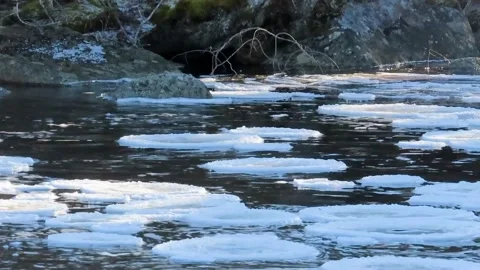 Chilly Winter River with Ice Floes and Snowy Rocks Stockbeeldmateriaal 348230048