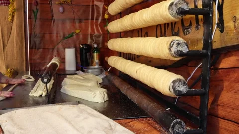 Chimney cake dough wrapped on rollers baking over heat Stockbeeldmateriaal 331811902