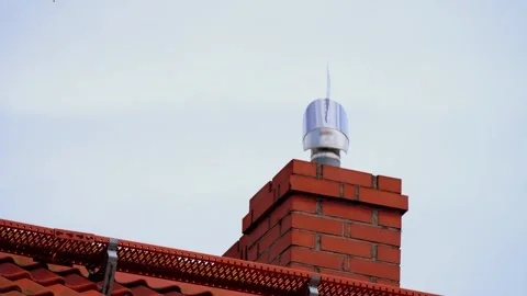 Chimney With Metal Rotating Cap on Red-Tiled Roof During Daylight Stock Footage 303378241