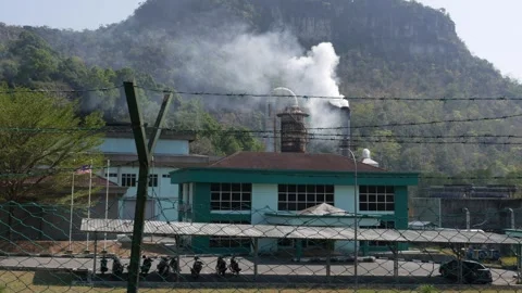 A chimney releases a steady stream of emissions as a waste plant processes Stock Footage 312337992