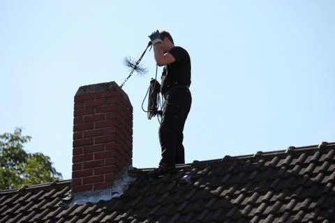 Chimney sweep inserting a brush Foto stock