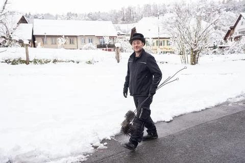 Chimney Sweep Walking Through Snow-Covered Neighborhood In Winter Stock Photos