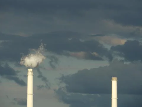 Chimneys of the heating plant in dramatic light Stock Photos
