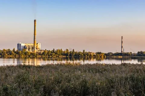 Chimneys of waste processing plants at the lake sunset Stock Photos