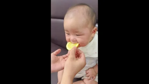 China: Baby makes funny faces while trying lemon for the first time in Sh... Stock Footage 345298111