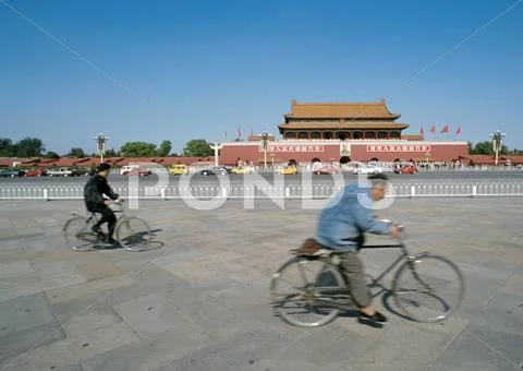 China, Beijing, Two People Riding Bicycles In Street In Front Of The Forbidden