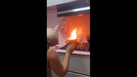 China: Boy panics as small kitchen fire is put out in Tianjin, China Stock Footage 330791116