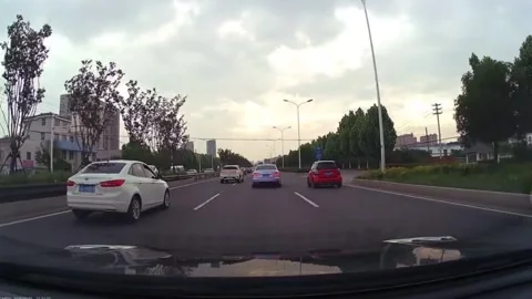 China: Car swerves into roadside gutter after sudden lane change in Nanji... Stock Footage 335636020