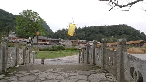 China cat on ancient bridge with flag of Tupu Village Stock Footage 73880728