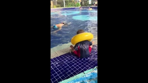China: Chinese boy jumps into pool with swim ring to save his drowning ... Stock Footage 341460667