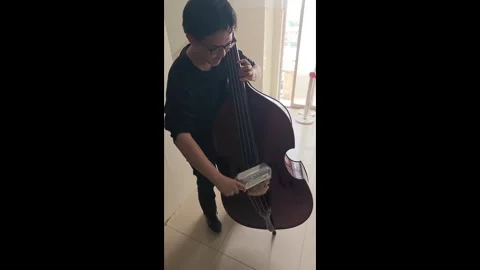 China: Creative Chinese student performs bach using a tea bottle as a cel... Stock Footage 321438718